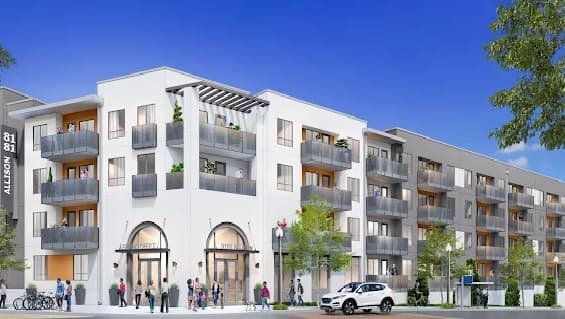 A modern four-story apartment building, 8181 Allison Apartments in La Mesa, features balconies and large windows. People walk on the sidewalk below, shaded by trees, all beneath a clear blue sky.